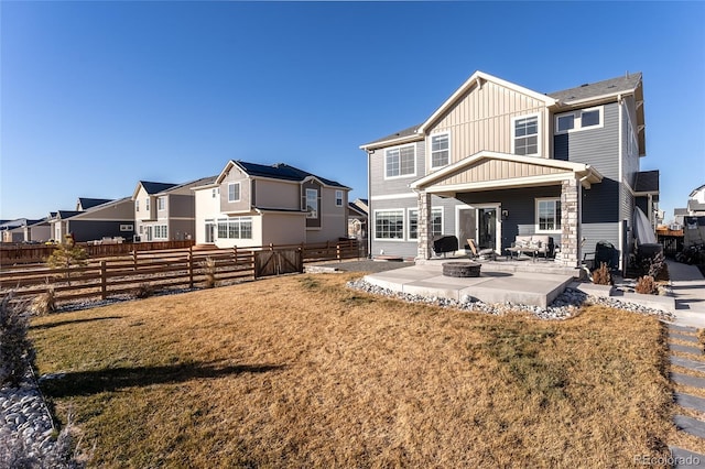 rear view of house with a yard, a fire pit, and a patio