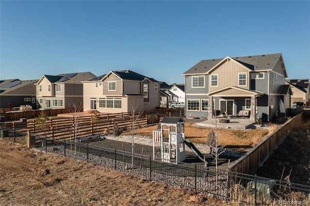 rear view of property with a patio and a playground