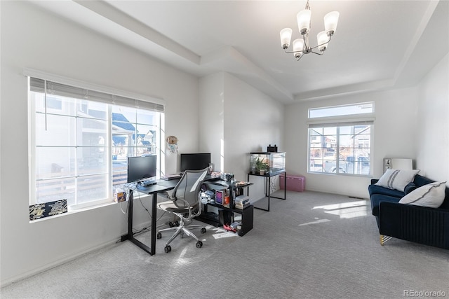 office space featuring carpet floors, a tray ceiling, and an inviting chandelier