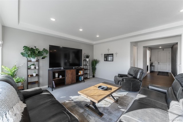 carpeted living room featuring a raised ceiling