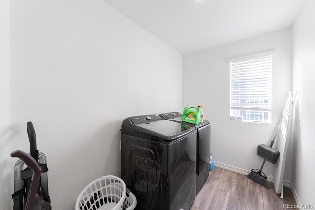 clothes washing area with light hardwood / wood-style floors and separate washer and dryer