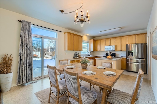 dining room featuring sink and an inviting chandelier