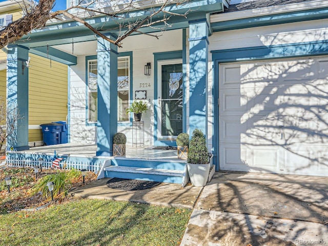 entrance to property featuring a porch and a garage