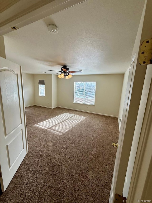 interior space featuring ceiling fan, carpet floors, and a textured ceiling