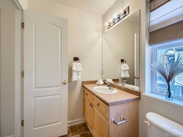 bathroom featuring vanity, tile patterned flooring, and toilet