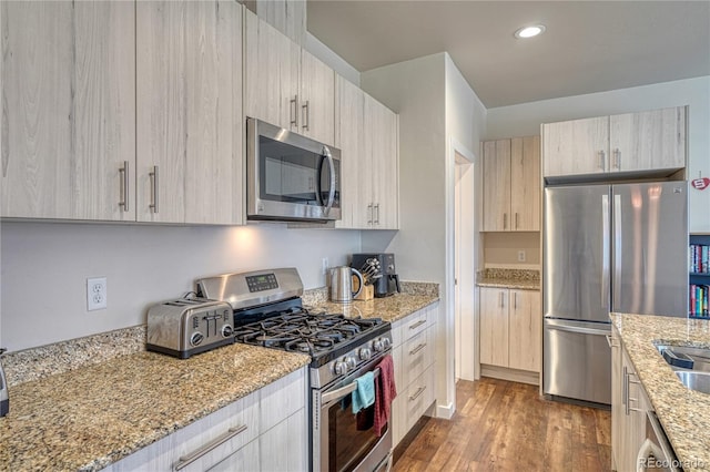 728 Oak St Unit F, Salida, CO 81201 - kitchen featuring appliances with stainless steel finishes, light stone counters, wood finished floors, modern cabinets, and recessed lighting