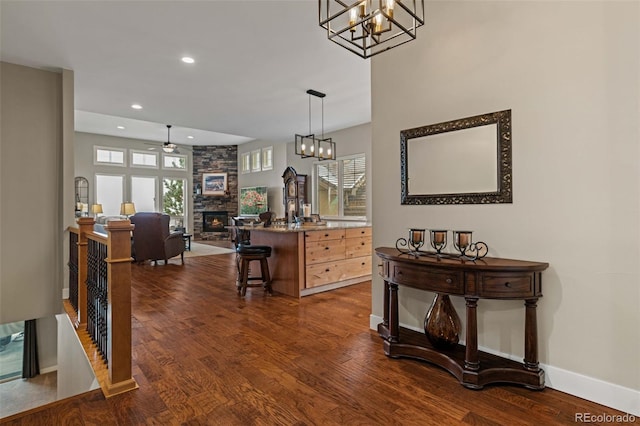 hallway with a notable chandelier, baseboards, recessed lighting, an upstairs landing, and dark wood-type flooring