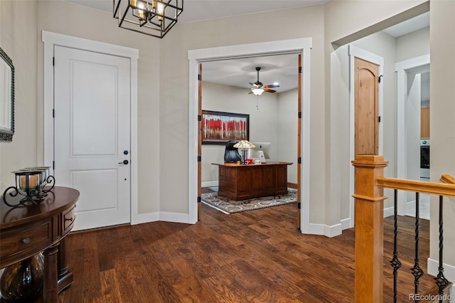 foyer with wood finished floors, ceiling fan with notable chandelier, and baseboards