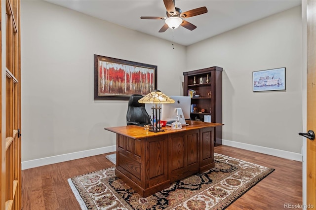 office featuring baseboards, a ceiling fan, and wood finished floors