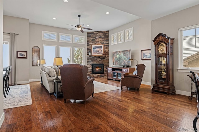 living room with baseboards, a stone fireplace, a ceiling fan, recessed lighting, and hardwood / wood-style floors