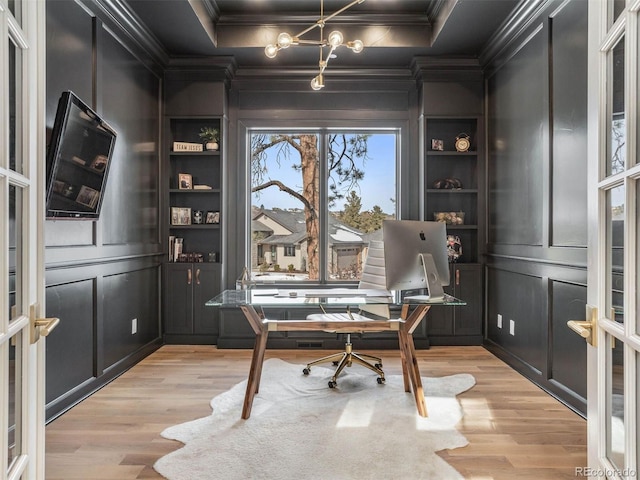 office space with french doors, crown molding, built in features, and light hardwood / wood-style flooring