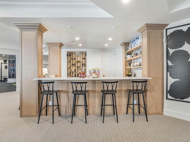 kitchen with ornate columns, a breakfast bar area, and kitchen peninsula