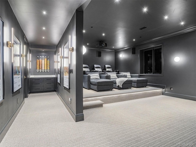 home theater with ornamental molding and light carpet