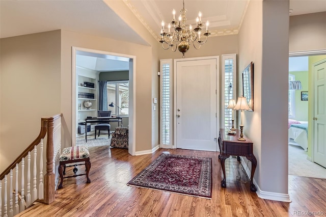 32 Silver Fox Cir, Greenwood Village, CO 80121 - foyer entrance with a chandelier, wood finished floors, baseboards, crown molding, and a tray ceiling