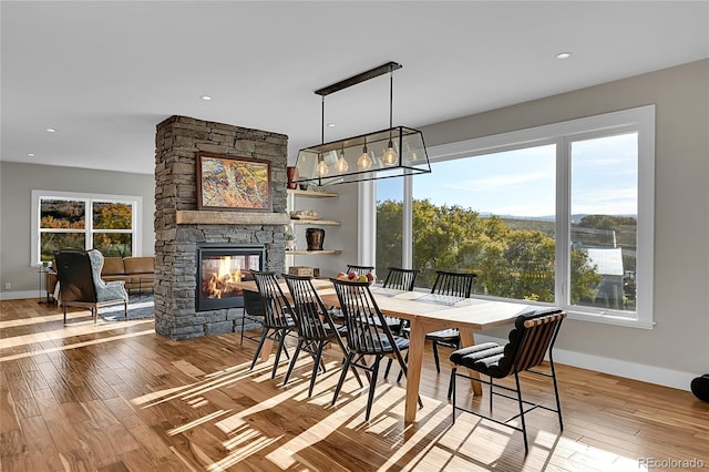 dining room with a fireplace and wood-type flooring