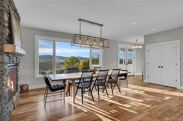 dining room with a mountain view, wood-type flooring, and a fireplace