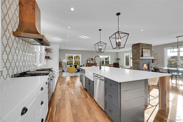 kitchen featuring decorative backsplash, gray cabinets, appliances with stainless steel finishes, decorative light fixtures, and white cabinetry