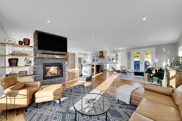 living room featuring hardwood / wood-style flooring, a fireplace, and french doors