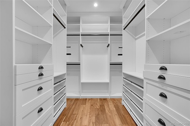 walk in closet with light hardwood / wood-style floors