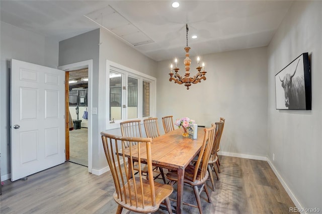 dining area featuring light wood-type flooring and a notable chandelier