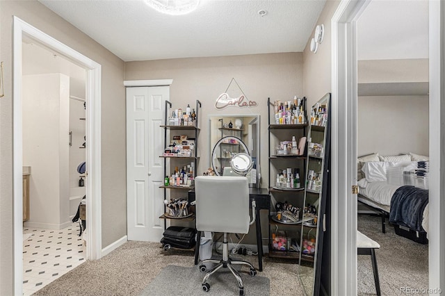 office area featuring baseboards, carpet floors, and a textured ceiling