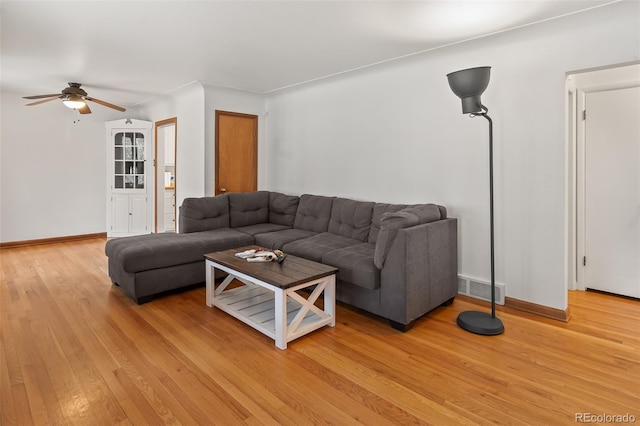 living room with light wood-type flooring and ceiling fan