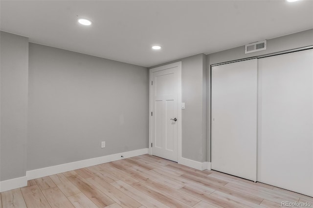 unfurnished bedroom featuring light hardwood / wood-style floors and a closet