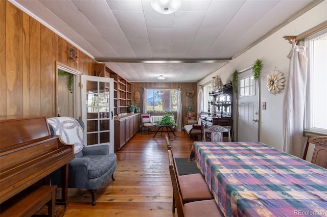 dining area with wooden walls and light wood finished floors