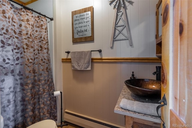 bathroom with toilet, a baseboard radiator, a sink, and a shower with shower curtain