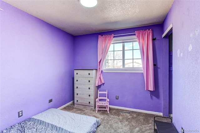 bedroom featuring a textured ceiling, carpet, visible vents, and baseboards