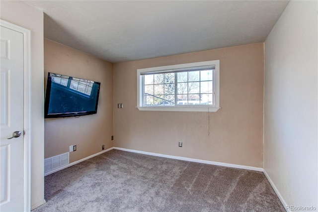 unfurnished room with carpet flooring, visible vents, and baseboards