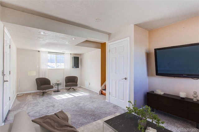 carpeted living area featuring a textured ceiling, baseboards, and stairs