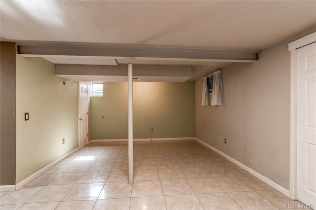 basement with light tile patterned floors and baseboards