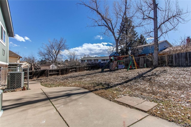 view of yard with a patio, a playground, and a fenced backyard