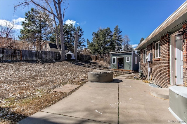 view of yard featuring an outbuilding, a fenced backyard, a patio, and a storage unit