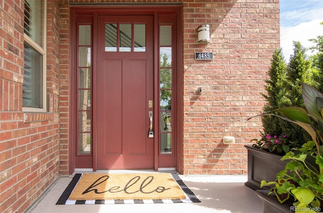 property entrance featuring brick siding