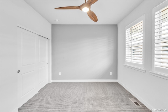 unfurnished bedroom with carpet flooring, a closet, baseboards, and a ceiling fan