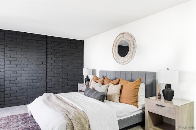 carpeted bedroom featuring brick wall