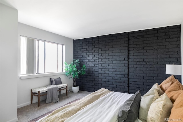 carpeted bedroom with brick wall