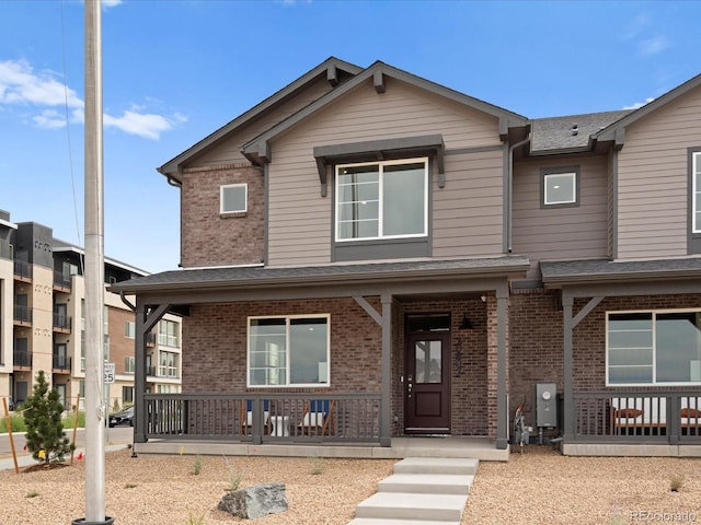 20802 E 66th Ave, Aurora, CO 80019 - view of front facade with a porch, brick siding, and roof with shingles