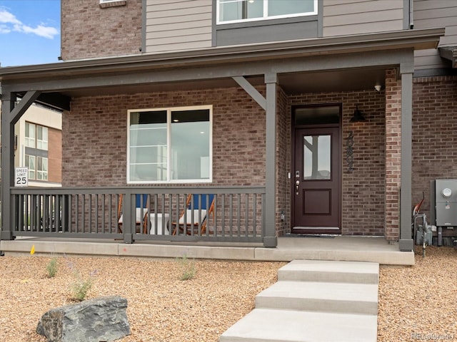 20802 E 66th Ave, Aurora, CO 80019 - view of exterior entry with a porch and brick siding