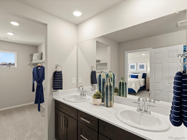 20802 E 66th Ave, Aurora, CO 80019 - bathroom featuring double vanity, ensuite bathroom, recessed lighting, and baseboards