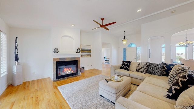 living room with light wood-style flooring, recessed lighting, a wealth of natural light, and a tile fireplace