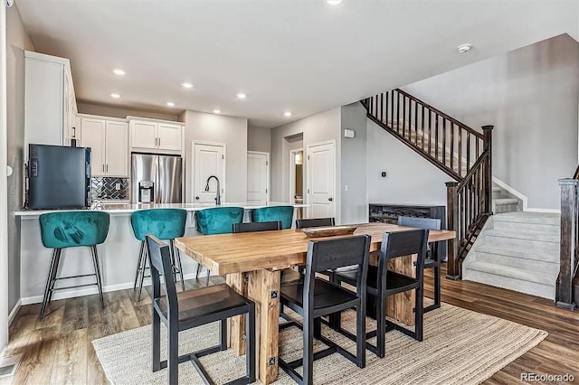 dining room featuring dark wood-style floors, stairs, baseboards, and recessed lighting