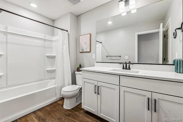 bathroom featuring toilet, wood finished floors, vanity, visible vents, and shower / bath combination with curtain