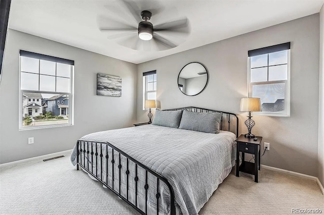 carpeted bedroom with ceiling fan, visible vents, and baseboards