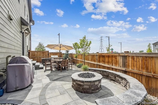 view of patio / terrace with an outdoor fire pit, a fenced backyard, area for grilling, and outdoor dining space