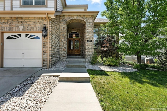 7809 S Coolidge Way, Aurora, CO 80016 - view of exterior entry featuring a yard, stone siding, and concrete driveway