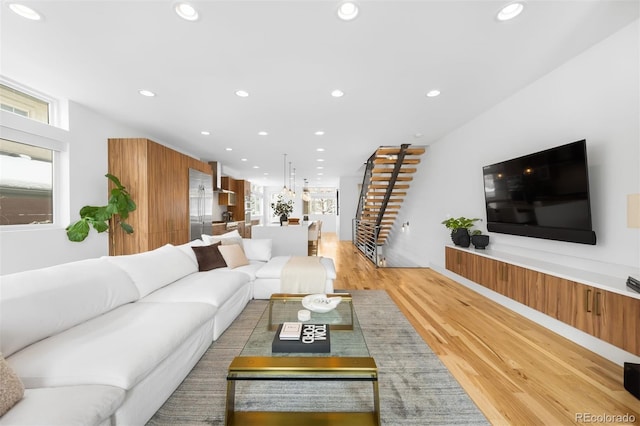 living area with light wood finished floors, stairs, and recessed lighting