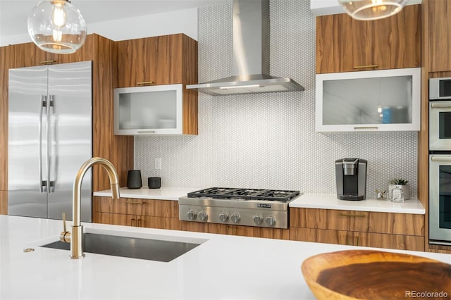 kitchen featuring wall chimney range hood, modern cabinets, stainless steel appliances, and brown cabinetry